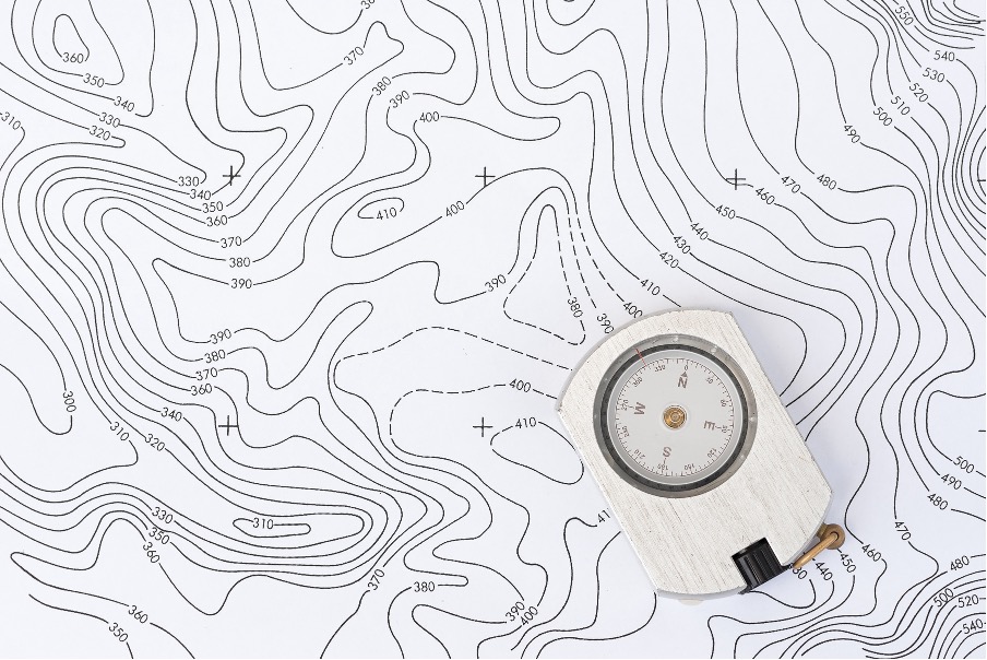 Compass on a topographic map — navigating complexity with a trusted guide
